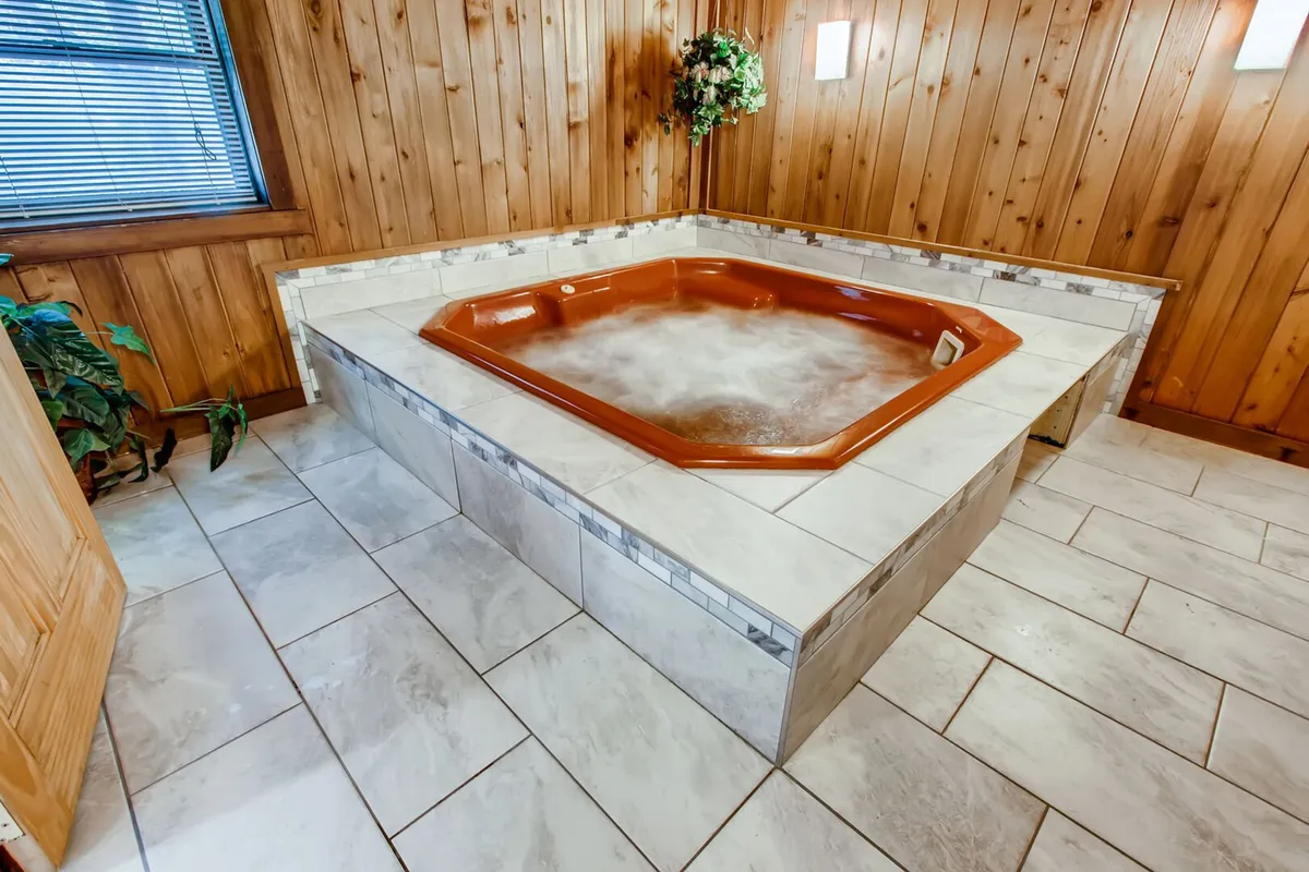 This image features a tranquil indoor jacuzzi set against warm wood paneling, with a decorative plant adding a touch of nature to the space. Soft lighting and serene ambiance evoke relaxation and rejuvenation after outdoor adventures.